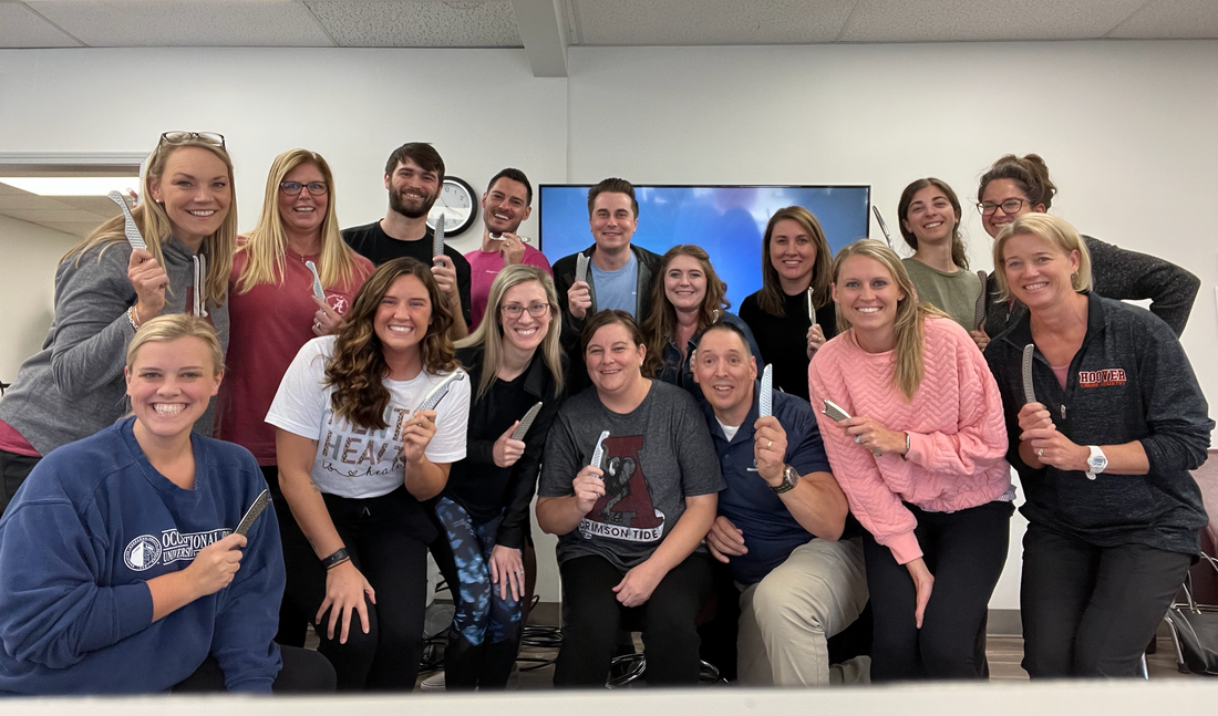 Clinicians holding HawkGrips tools at a Level I: IASTM Fundamentals course led by Occupational Therapist, Dr. Jim Wagner.
